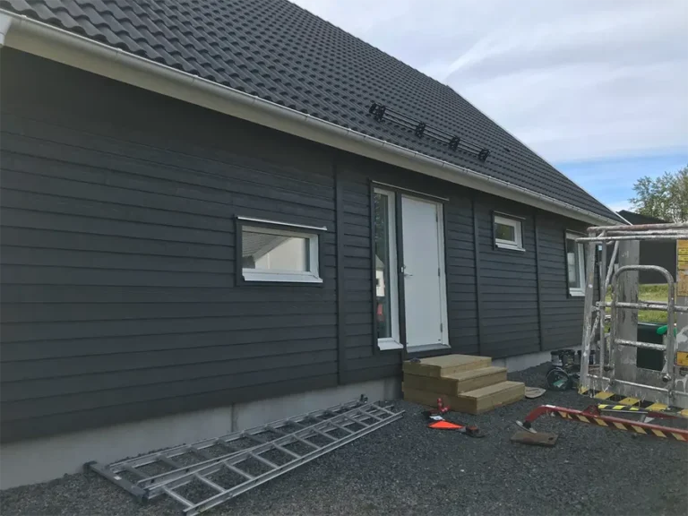 Ett pågående byggprojekt med byggställning framför ett svartmålat trähus med nytt tak. Våra erfarna hantverkare från AF Byggservice säkerställer trygga resultat från första kontakt till klart projekt i Jönköpings län.