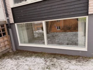 Stora nya fönster monterade på nedre plan av hus i Huskvarna efter fönsterbyte.