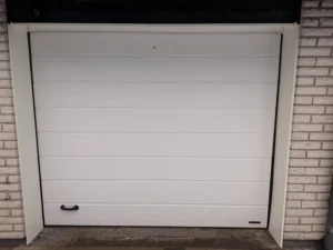 Vit garageport med ny motor monterad på garage i Huskvarna.