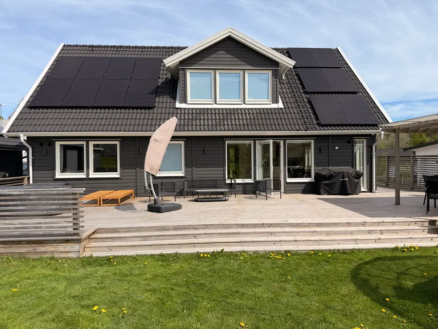 Färdigmålad villa i Vetlanda med svart träfasad, solceller på taket och stor träaltan