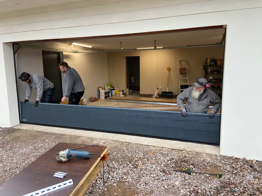 Montörer installerar garageport i garage för kund i Eksjö