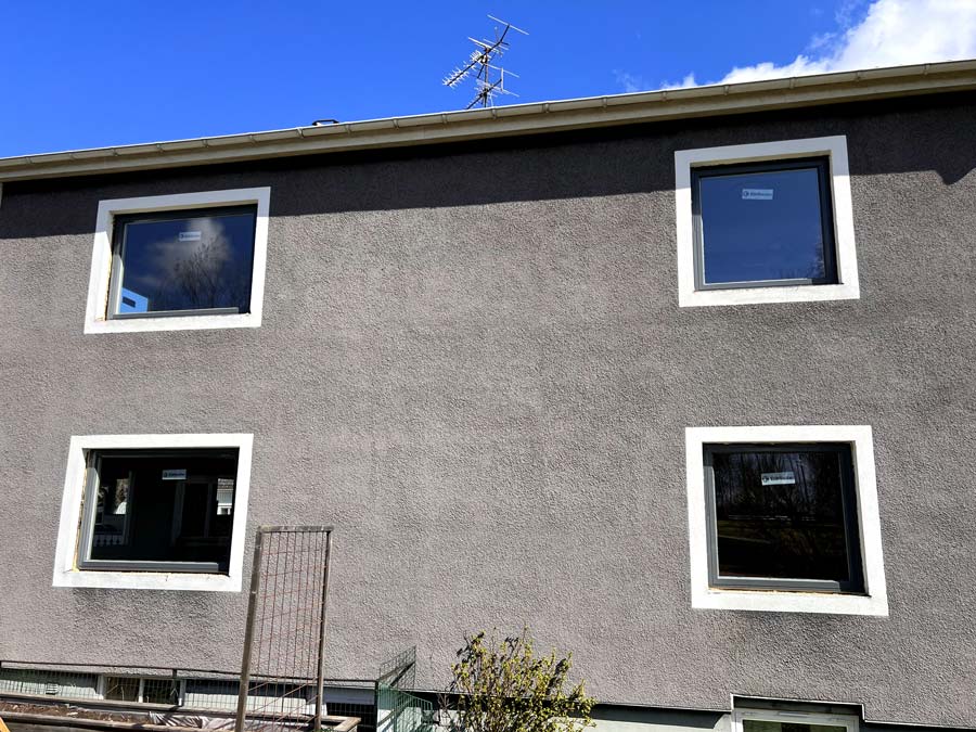 Villafasad med flera nya fönster i antracit efter ett fönsterbyte