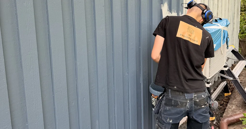 Målare från AF Byggservice målar om en träfasad i ny kulör på en villa i Vetlanda