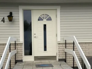 Ny gräddvit ytterdörr med välvt spröjsfönster och sidoljus på villa i Nässjö, monterad av AF Byggservice