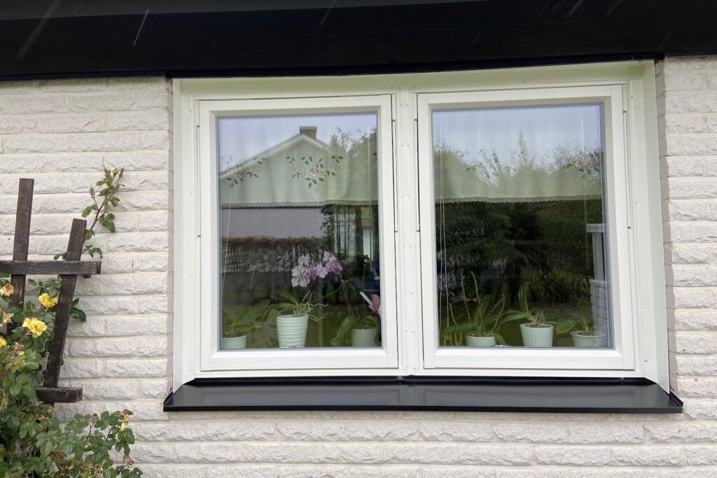 Nytt vitt tvåluftsfönster med svart fönsterbleck på villa i Vetlanda, monterat av AF Byggservice