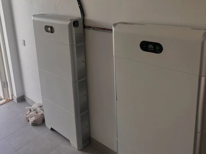 Två Huawei batterilager för solel som står på golvet mot väggen i ett teknikrum, kablarna från växelriktaren kommer ner längs väggen
