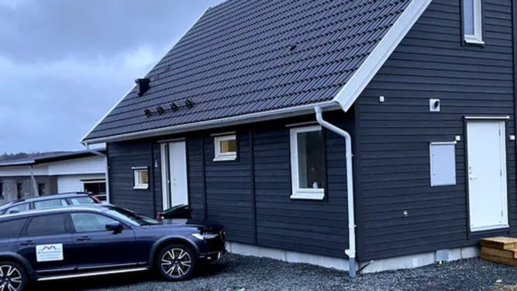 Snörasskydd monterat på takfallet rakt ovanför entrédörren på en villa med mörkt tak i Jönköping, fyra konsoler längs takfoten